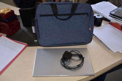 a laptop and headphones sitting on a desk next to a bag