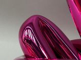 a shiny pink sculpture of a flower on a table