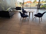 trois chaises et une table dans le hall d'un immeuble