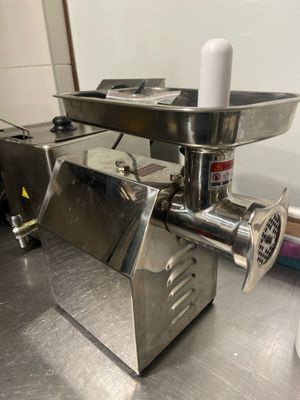 un hachoir à viande posé sur un plan de travail dans une cuisine