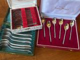 several spoons and forks are in a case on a table