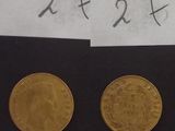 deux pièces d'or posées l'une à côté de l'autre sur une feuille de papier