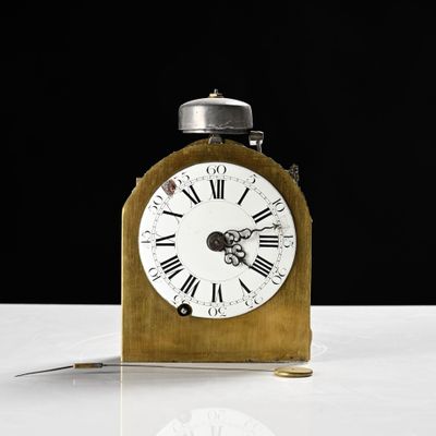 une petite horloge en bois avec des chiffres romains sur le cadran