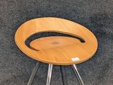 a wooden stool with metal legs on a carpeted floor
