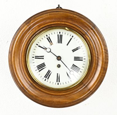 a clock hanging on the wall with roman numerals on it