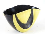 a black and yellow bowl sitting on a white surface
