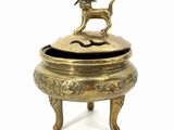 a small brass box with a dog on top of it