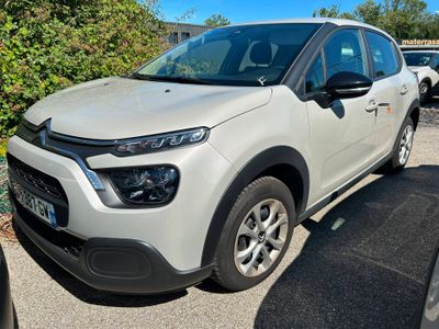La Citroën blanche est garée sur un parking avec d'autres voitures