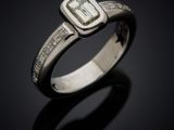 a white gold ring with an emerald stone surrounded by diamonds