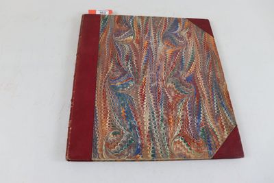 un gros plan d'un livre posé sur une surface blanche, avec une couverture rouge