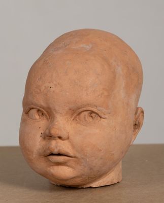 une tête de bébé en argile posée sur une table