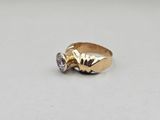 a close up of a gold ring with two diamonds on it