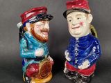 pair of ceramic figurines of two men with hats and beards