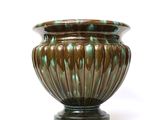 a vase that is sitting on a stand on a white surface