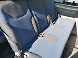 three seats in the back of a van with a blue seat cover
