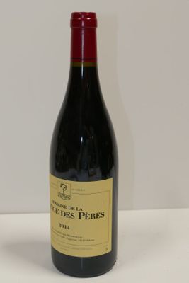 une bouteille de vin rouge posée sur une table blanche