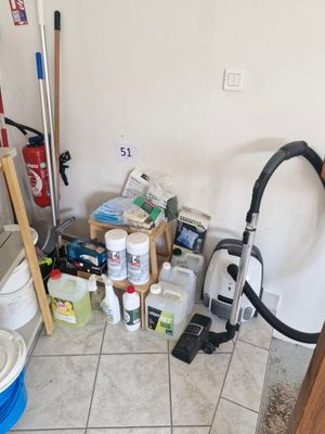 a room with a vacuum, buckets, and other cleaning supplies on the floor