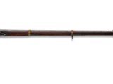 un vieux pistolet avec une crosse en bois et une crosse en métal