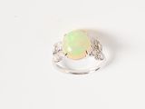 an oplite and diamond ring on a white background