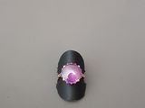 un gros plan d'une bague sertie d'une pierre rose