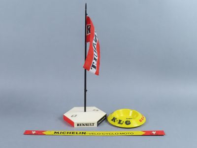 un casque de chantier jaune et un drapeau rouge et blanc à côté d'une règle