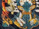 un tissu bleu et orange sur lequel est représenté un oiseau et des fleurs