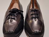 pair of black leather shoes with laces on them on a white surface