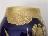 a blue vase with a gold decoration on it