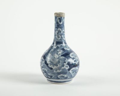 un petit vase bleu et blanc orné de nuages