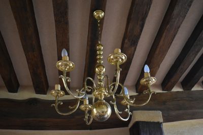 a gold chandelier hanging from the ceiling in a room