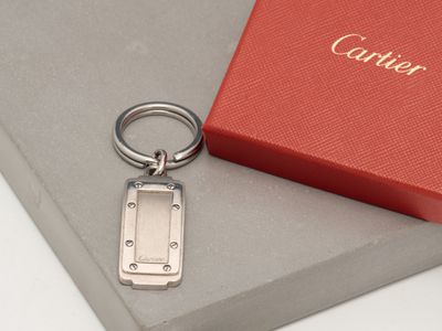a silver keychain sitting on top of a red box