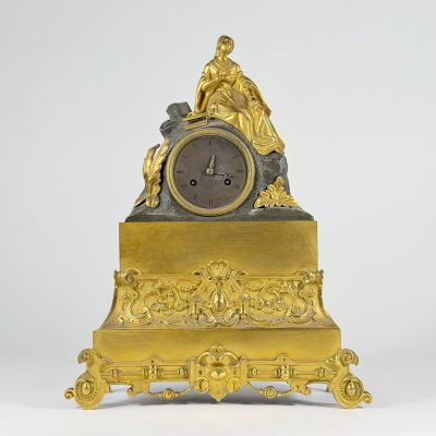 a gold clock with a statue on top of it