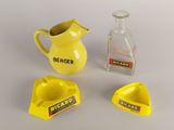 a yellow pitcher and two ashtrays next to a glass bottle
