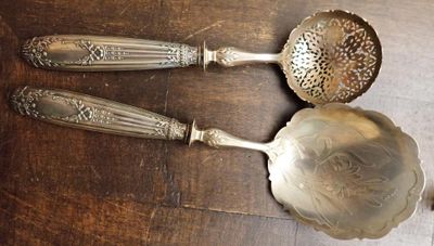 trois cuillères en argent et une cuillère doseuse posées sur une table en bois