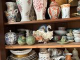Il y a toutes sortes de vases et d'assiettes sur cette étagère