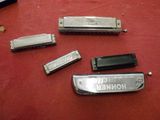 four harmonicas sitting on a table with a red table cloth