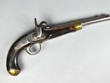 un vieux pistolet posé sur une surface blanche