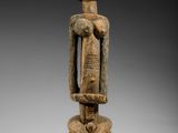 une statue en bois représentant un homme avec un serpent autour du cou
