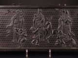 une vieille plaque métallique sur laquelle figure un groupe de personnes