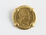 gros plan d'une pièce d'or sur une surface blanche