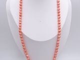 un gros plan d'un collier porté par un mannequin posé sur un support en bois