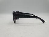 une paire de lunettes de soleil noires posée sur une surface blanche