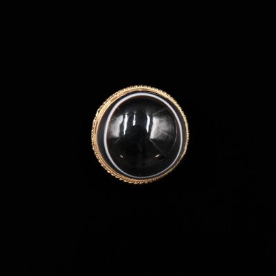 un gros plan d'une bague en pierre noire sur fond noir