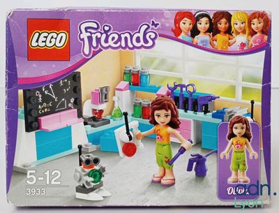 une boîte contenant un ensemble Lego Friends avec une petite fille et un chien