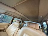 beige leather seats in the back of a car with a man sitting in the passenger seat