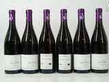 six bouteilles de vin sont alignées sur une table