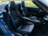 the interior of a blue sports car with black leather seats