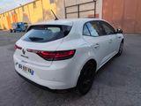 the rear end of a white car parked in a parking lot