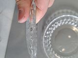 a person holding a piece of plastic in front of a bowl