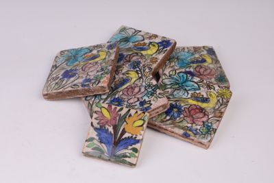 quatre carreaux ornés de fleurs et d'oiseaux sur un fond blanc